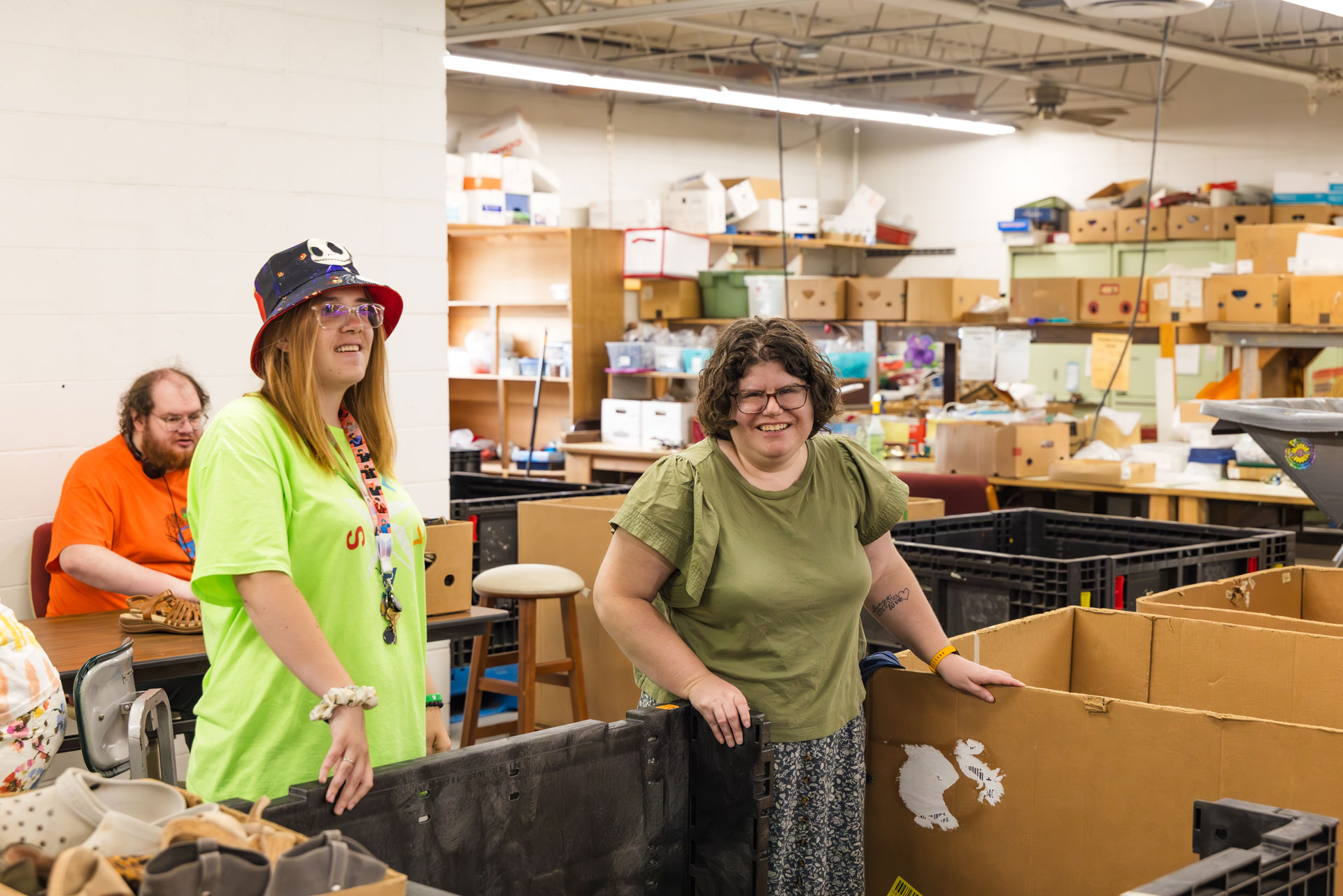 Two women in a room with many cardboard boxes