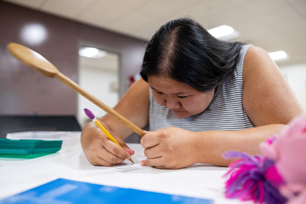 A woman focusing on a piece of paper she's writing on