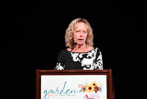 Susan Mielcarek speaking at the Garden Gala podium.