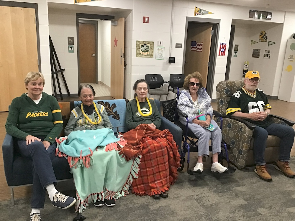 Members of small group dementia care show off their Packer pride with Green Bay Packer-themed attire and accessories