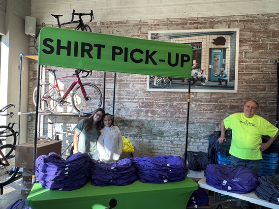 three volunteers at the T-shirt pick-up booth