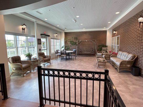 The back porch area at Yesteryear Village with outdoor seating and a porch swing. Great view of the courtyard.