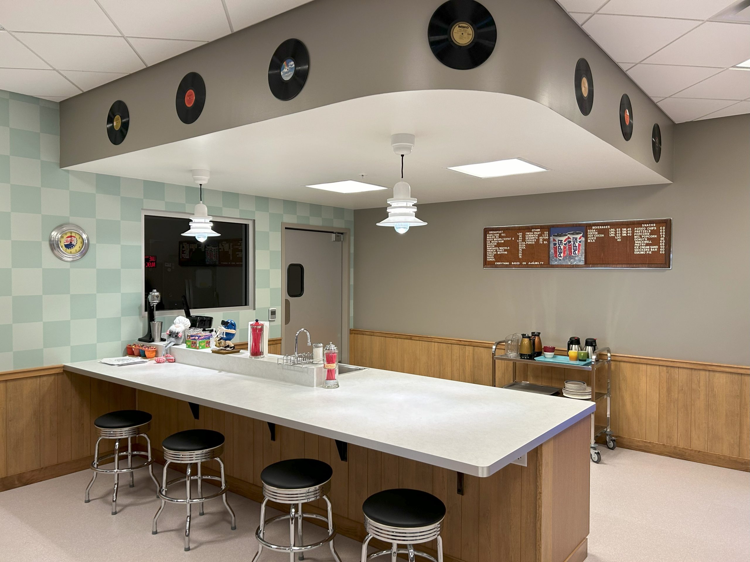 Diner counter and kitchen at Yesteryear village complete with records, stools, and retro diner menu.